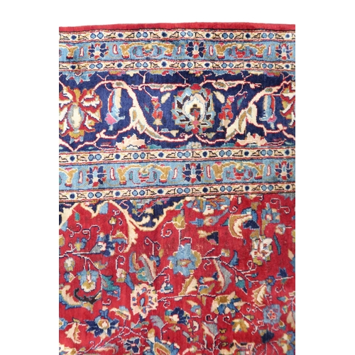 2126 - A LARGE RED GROUND TRADITIONAL PERSIAN MASHED RUG with light & dark blue central medallion ... 