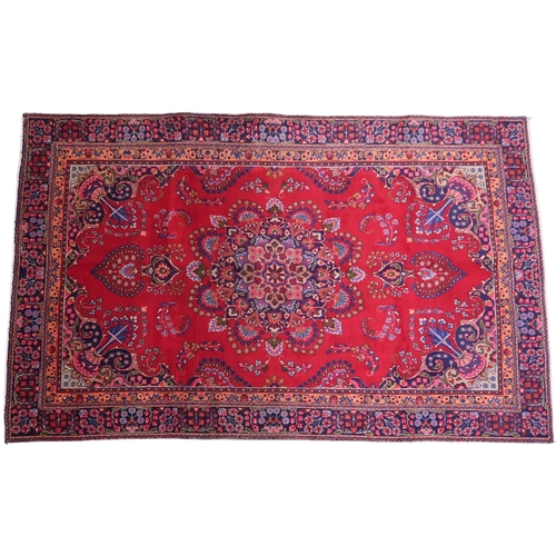 2132 - A RICH RED GROUND PERSIAN RUG with multicoloured sunburst central medallion and matching spandr... 