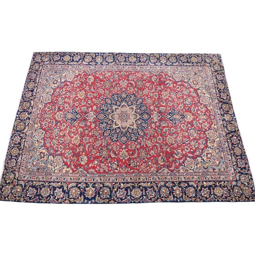 2134 - A RED GROUND TABRIZ RUG with dark blue and ivory sunburst central medallion and light blue and ... 