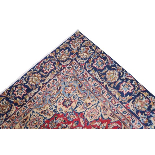 2134 - A RED GROUND TABRIZ RUG with dark blue and ivory sunburst central medallion and light blue and ... 