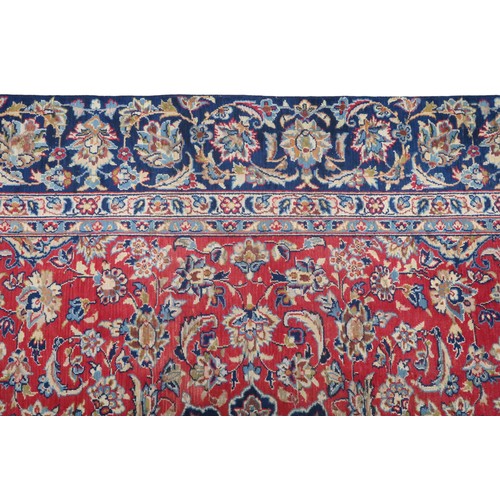 2134 - A RED GROUND TABRIZ RUG with dark blue and ivory sunburst central medallion and light blue and ... 