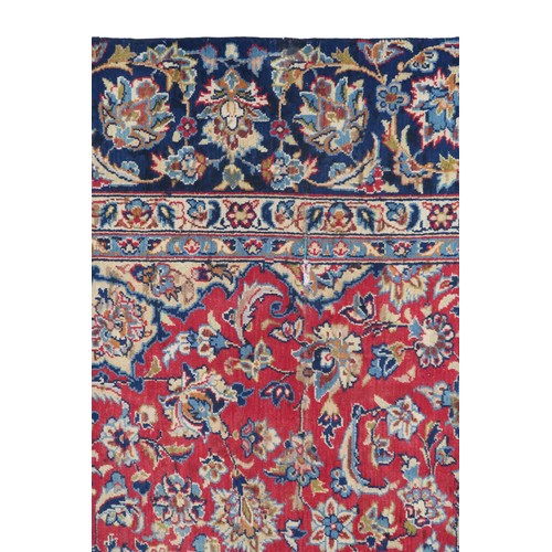 2134 - A RED GROUND TABRIZ RUG with dark blue and ivory sunburst central medallion and light blue and ... 