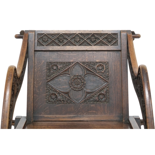 2034 - A 19TH CENTURY OAK GLASTONBURY CHAIR backrest and arms carved with Gothic floral/foliate motifs... 