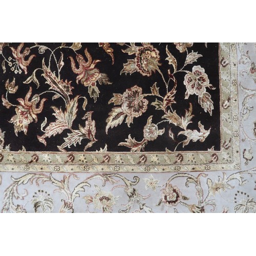 2121 - A LARGE DARK GROUND INDIAN WOOL ZEIGLER STYLE RUG with floral/foliate patterned ground within beige ... 