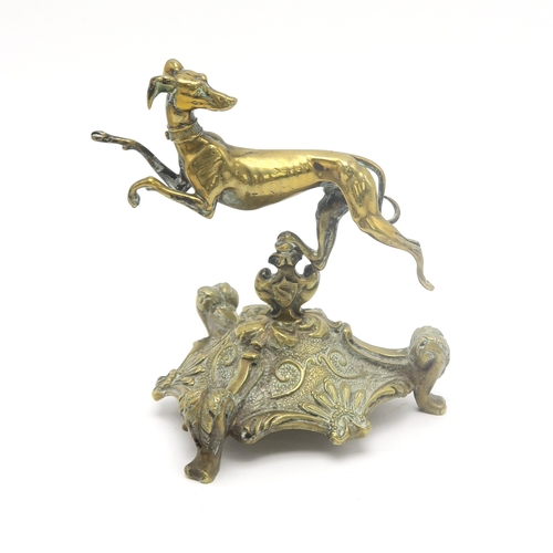 2669C - A CANINE DESK ORNAMENTFormed as a striding greyhound on triform base, standing approx. 12.5cm in hei... 