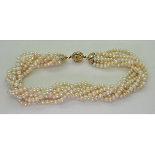 2820 - MULTI STRAND PEARLSwith a fancy fan patterned yellow and white 9ct gold box clasp, the cream freshwa... 