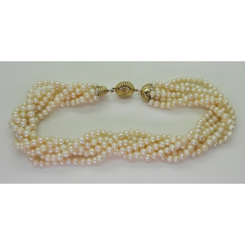 2820 - MULTI STRAND PEARLSwith a fancy fan patterned yellow and white 9ct gold box clasp, the cream freshwa... 