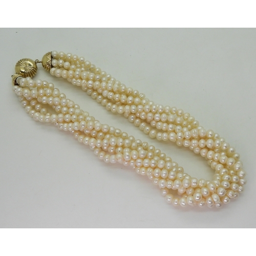 2820 - MULTI STRAND PEARLSwith a fancy fan patterned yellow and white 9ct gold box clasp, the cream freshwa... 