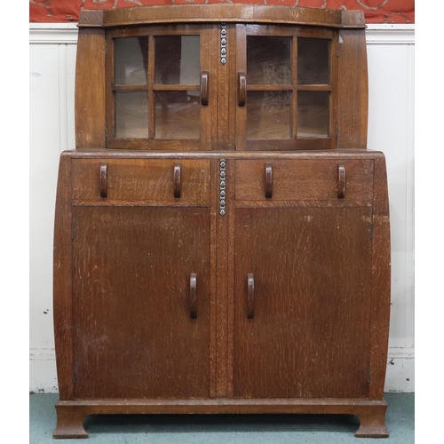 14 - An early 20th century oak Art Deco sideboard with pair of bow fronted glazed doors over two short dr... 