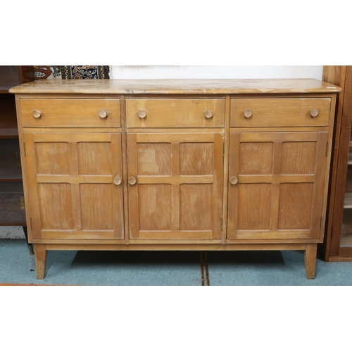 20 - A mid 20th century elm and beech Ercol style sideboard with shaped top over three short drawers over... 