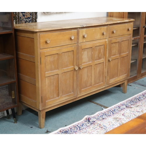 20 - A mid 20th century elm and beech Ercol style sideboard with shaped top over three short drawers over... 