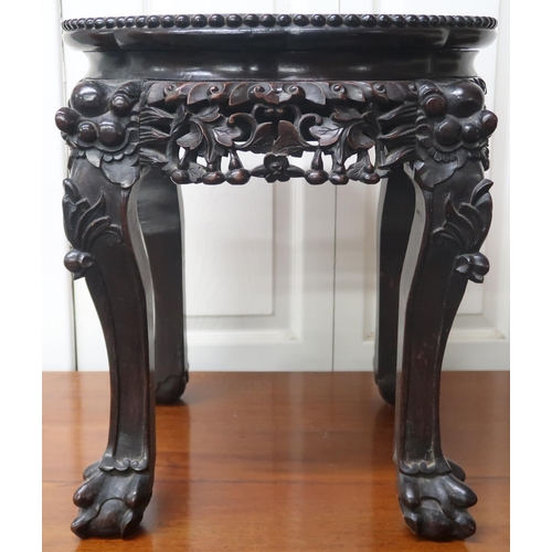 28 - A Chinese hardwood jardinière stand with marble inset top over pierced friezes on carved ball... 