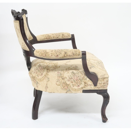 29 - A Victorian ebonised parlour armchair with floral upholstery applied to back, arms and seat on cabri... 