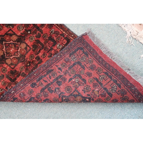 45 - A terracotta ground Persian rug with twinned geometric medallion design within narrow border, 103cm ... 