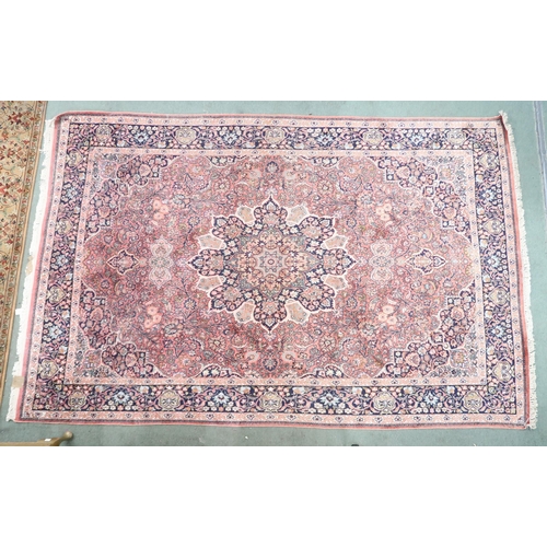 47 - A pink ground Tabriz rug with dark blue sunburst central medallion and matching spandrels on a flora... 