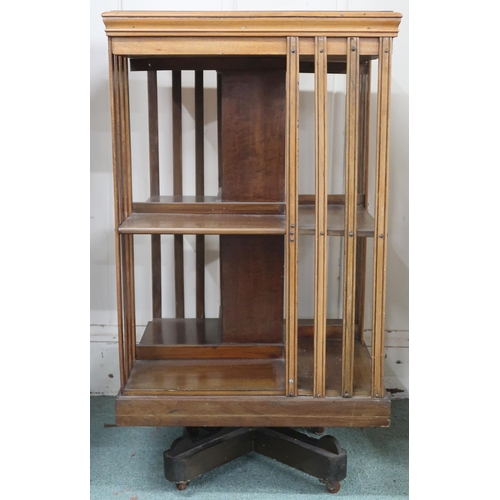 49 - An early 20th century mahogany revolving bookcase with square top over two tiers of shelves with bat... 