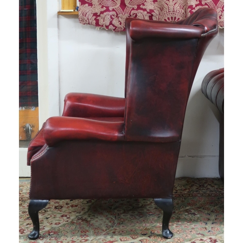 56 - A 20th century oxblood leather upholstered Chesterfield wingback armchair, 118cm high x 93cm wide x ... 