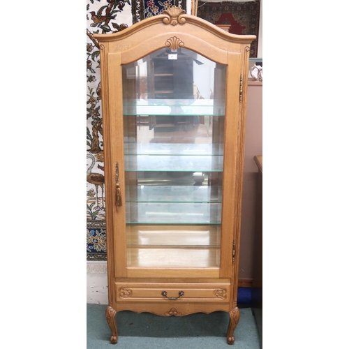 61 - A contemporary oak continental style glazed display cabinet with arched corniced top over glazed doo... 