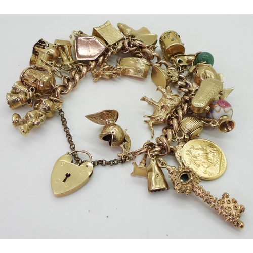 700 - A 9ct gold extensive charm bracelet, with twenty-nine attached charms to include a 1912 gold full so... 