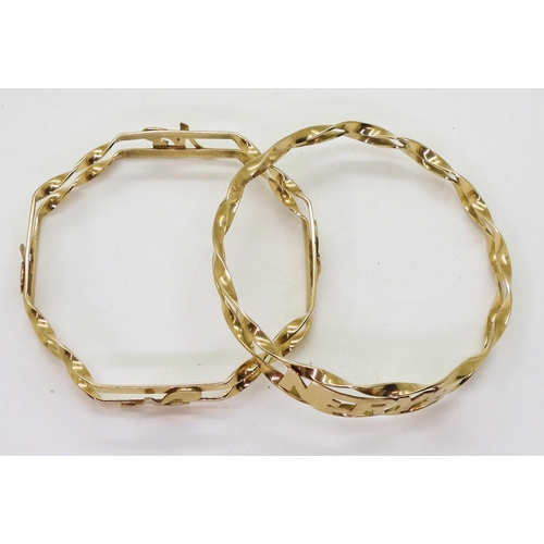 705 - Two yellow metal handmade bangles, one with a pattern of the inital 'N' the other with the name 'Ner... 