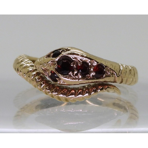 728 - A 9ct gold snake ring, set with garnets, size Q, London 1973 hallmarks  weight 3.9gms