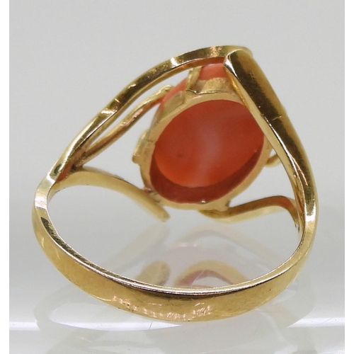 735 - A yellow metal ring set with a coral, size Q, weight 3.8gms