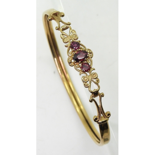 747 - A 9ct gold garnet set bangle, inner diameter approx 5cm, weight 5.7gms