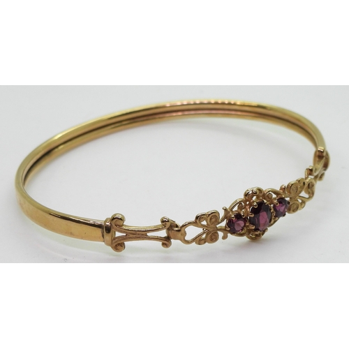 747 - A 9ct gold garnet set bangle, inner diameter approx 5cm, weight 5.7gms