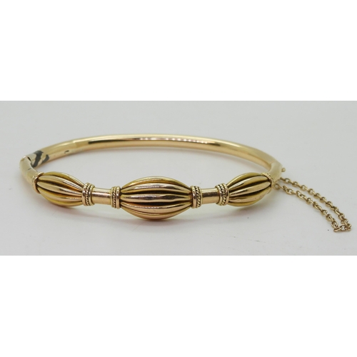 750 - A yellow metal bangle, with oval pleated bead design (af) diameter 6.2cm, weight 12gms