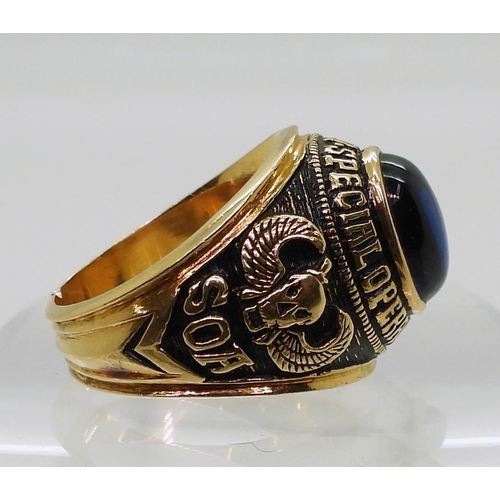 849 - A bright yellow metal American style college ring, stamped 90%, set with a blue glass gem embossed S... 