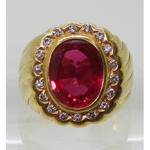 861 - A yellow metal ring, stamped 90%, set with a red gem, and diamonds with an estimated approx diamond ... 