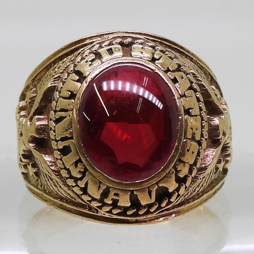 863 - A 10K gold American style college ring set with a red gem, embossed with United States Navy, finger ... 