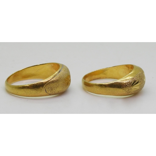 868 - Two bright yellow metal rings, with star engraved pattern, sizes Q, and P, one stamped with Chinese ... 