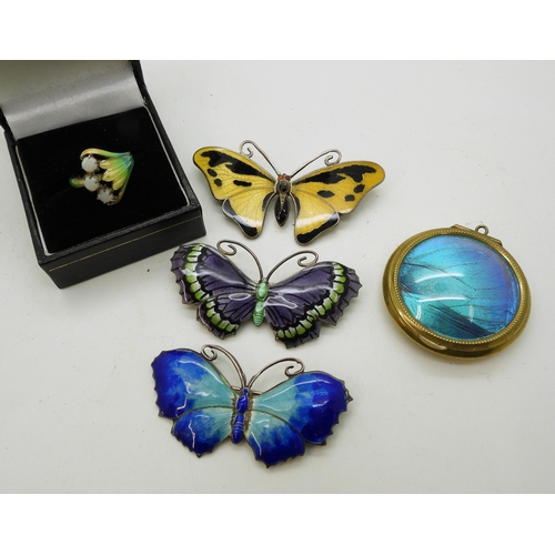 911 - Three butterfly brooches, two in silver and the yellow example in white metal, a silver cold enamel ... 