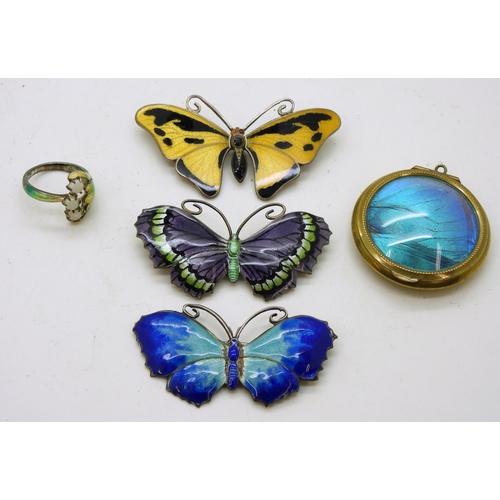 911 - Three butterfly brooches, two in silver and the yellow example in white metal, a silver cold enamel ... 