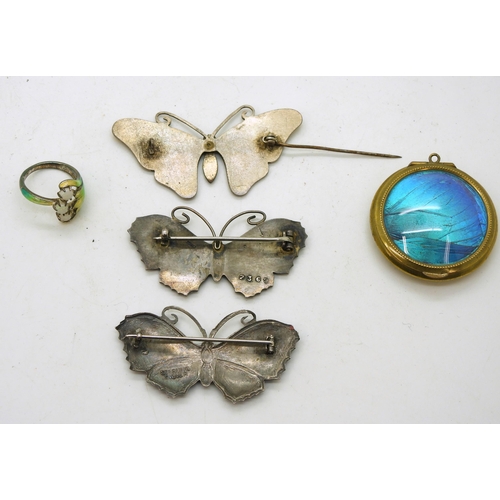 911 - Three butterfly brooches, two in silver and the yellow example in white metal, a silver cold enamel ... 