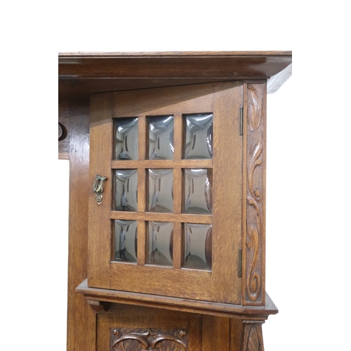 2040 - AN  OAK ARTS & CRAFTS MIRROR BACK SIDEBOARD bevelled mirror back flanked by glazed cabinets on s... 