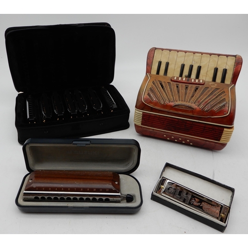 426 - A piano accordion music box together with a Suzuki G-48 wooden cover harmonica and various blues har... 