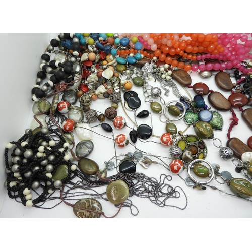 946 - A collection of statement beads and necklaces in a vanity case with applied leaves