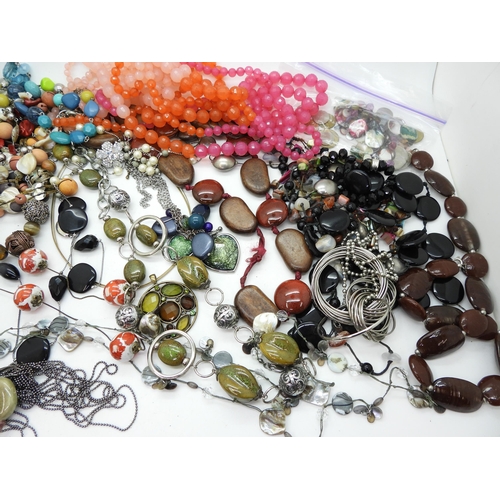 946 - A collection of statement beads and necklaces in a vanity case with applied leaves