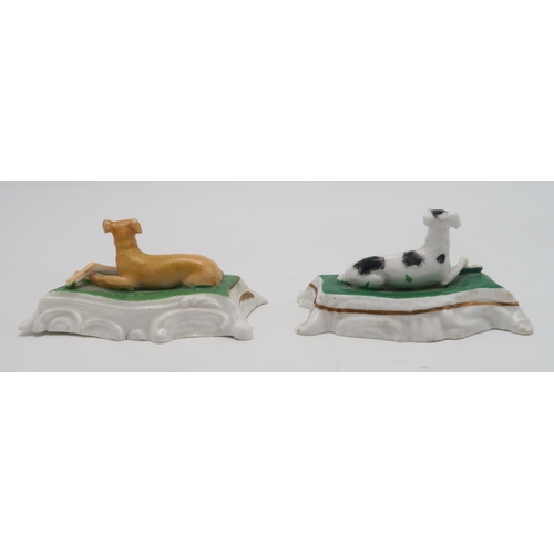 2329 - TWO PORCELAIN MODELS OF GREYHOUNDS OR WHIPPETSprobably Staffordshire, each modelled sitting on a cus... 