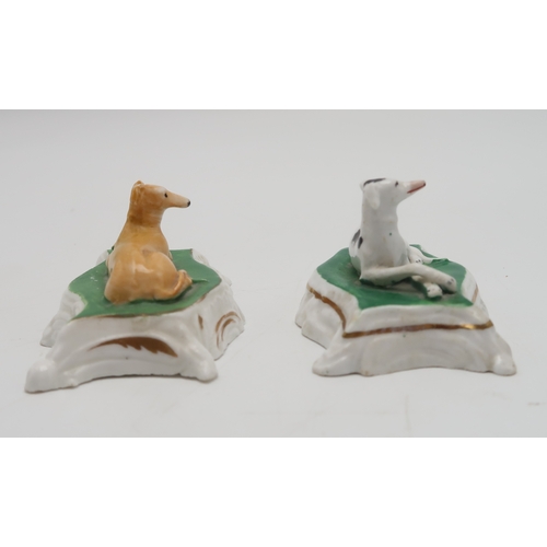 2329 - TWO PORCELAIN MODELS OF GREYHOUNDS OR WHIPPETSprobably Staffordshire, each modelled sitting on a cus... 