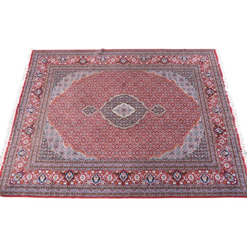 2138 - A RED GROUND TRADITIONAL BIJAR CARPET with dark and light blue central medallion and matching spandr... 