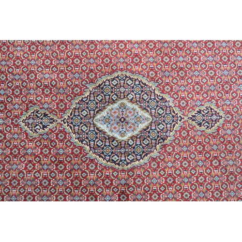 2138 - A RED GROUND TRADITIONAL BIJAR CARPET with dark and light blue central medallion and matching spandr... 