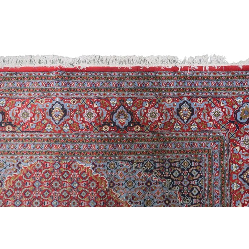 2138 - A RED GROUND TRADITIONAL BIJAR CARPET with dark and light blue central medallion and matching spandr... 