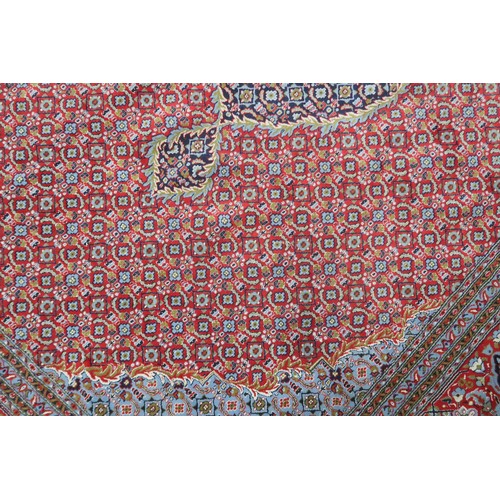 2138 - A RED GROUND TRADITIONAL BIJAR CARPET with dark and light blue central medallion and matching spandr... 