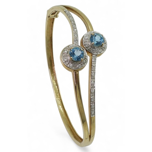 706 - A 9ct gold blue topaz and diamond accent bangle, inner diameter 6.6cm, weight 16.4gms 