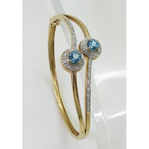 706 - A 9ct gold blue topaz and diamond accent bangle, inner diameter 6.6cm, weight 16.4gms 