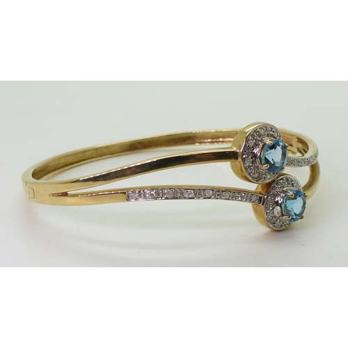 706 - A 9ct gold blue topaz and diamond accent bangle, inner diameter 6.6cm, weight 16.4gms 