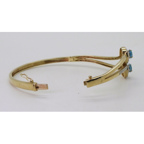 706 - A 9ct gold blue topaz and diamond accent bangle, inner diameter 6.6cm, weight 16.4gms 